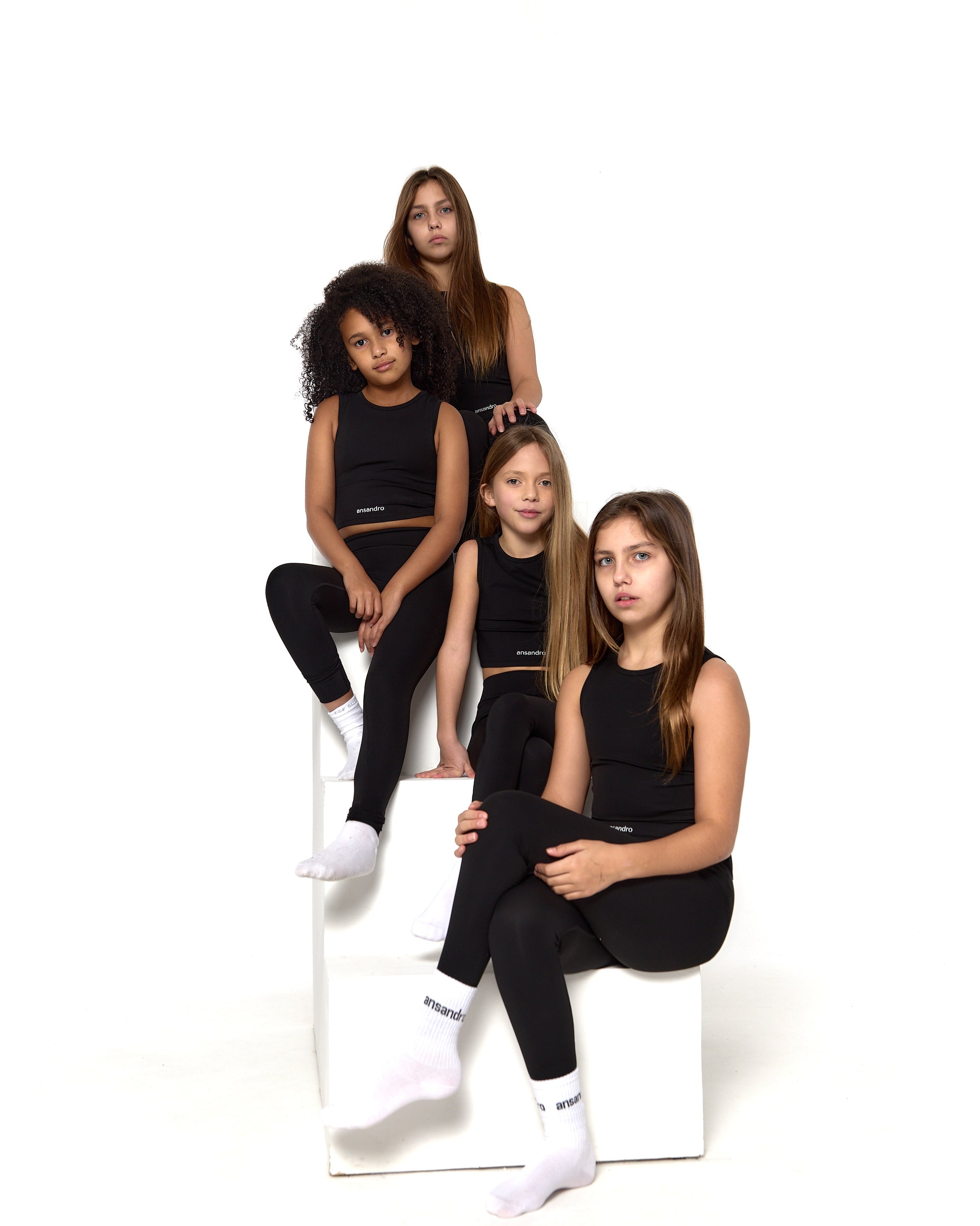 Ansandro girls' cropped tank in black - premium kids' activewear with matching black high-waisted leggings and branded socks front view
