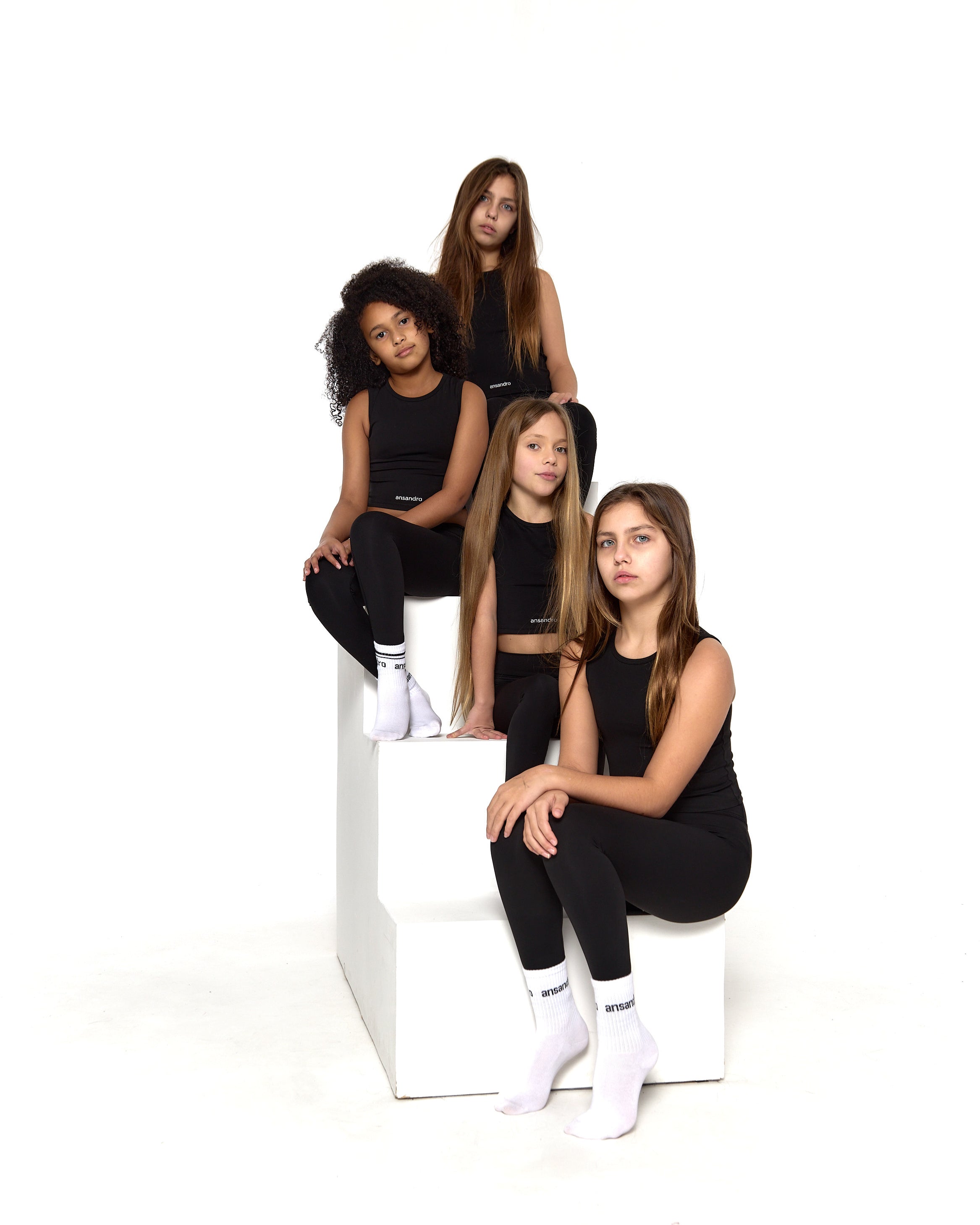 Ansandro girls' cropped tank in black - premium kids' activewear with matching black high-waisted leggings and branded socks side view