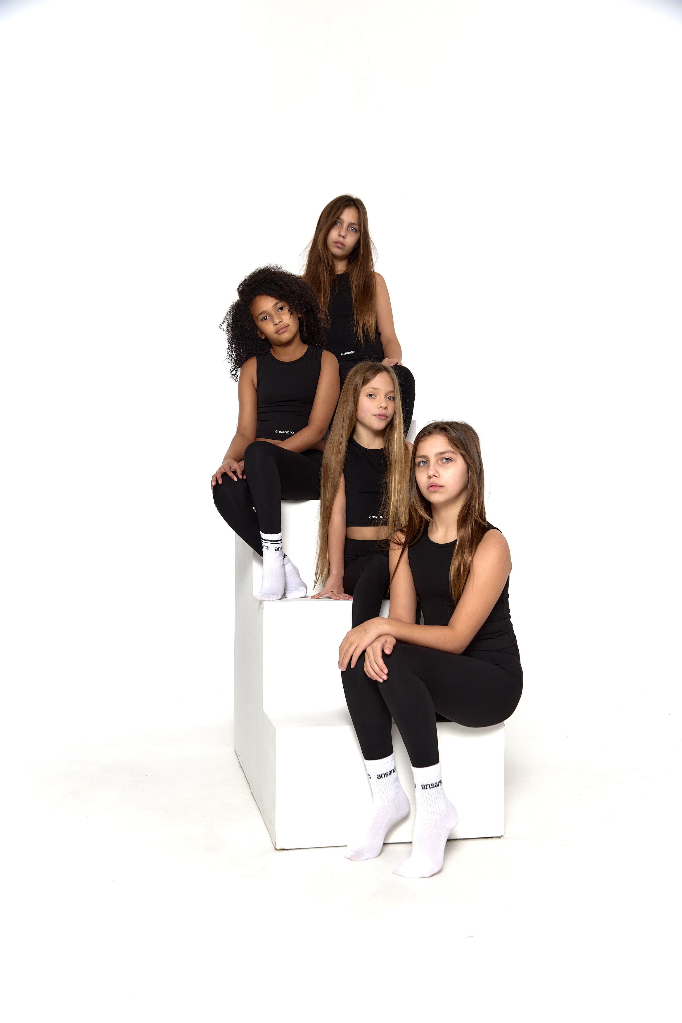 Ansandro girls' cropped tank in black - premium kids' activewear with matching black high-waisted leggings and branded socks side view