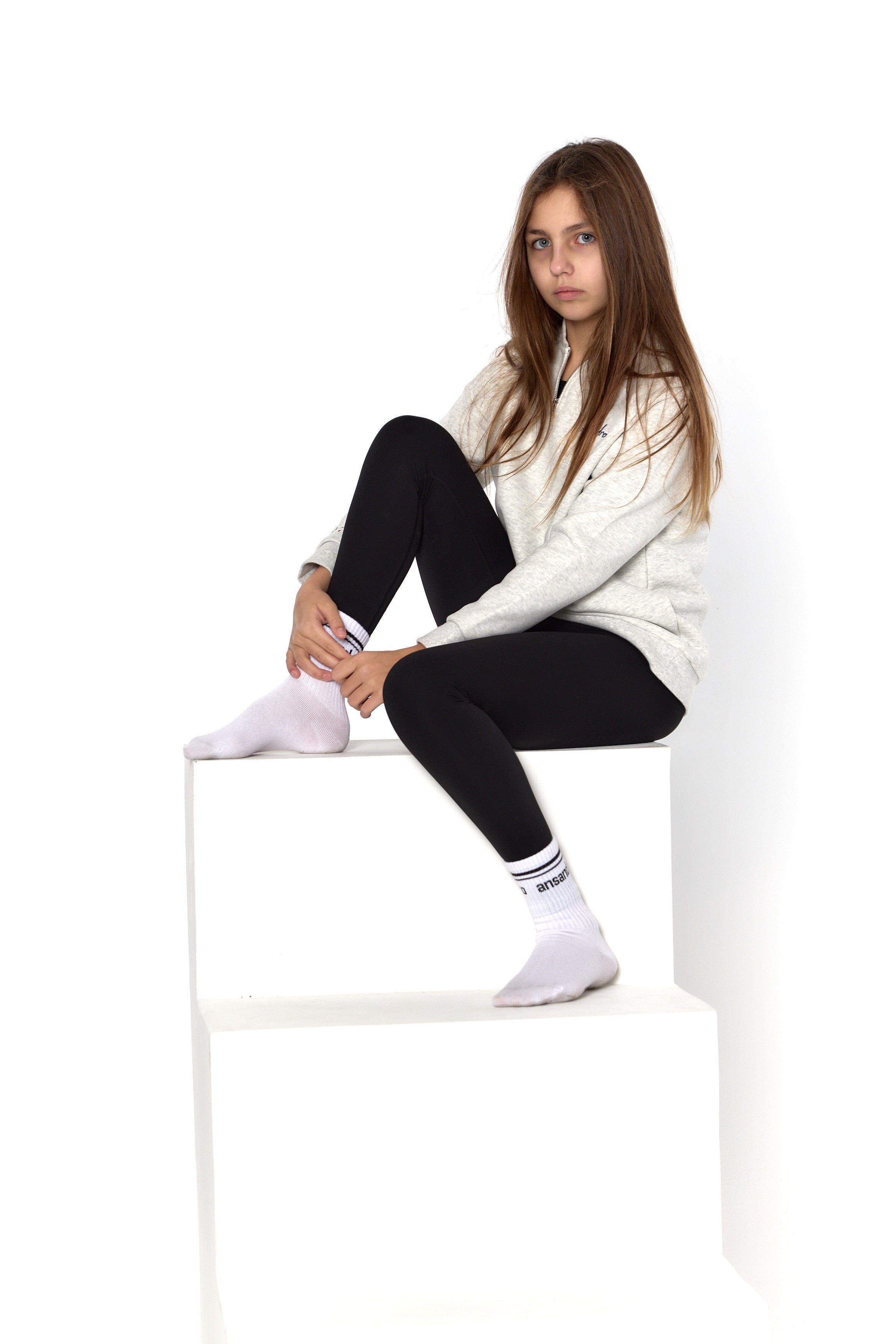 Stylish black high-waisted leggings for girls - perfect for active kids paired with branded socks.