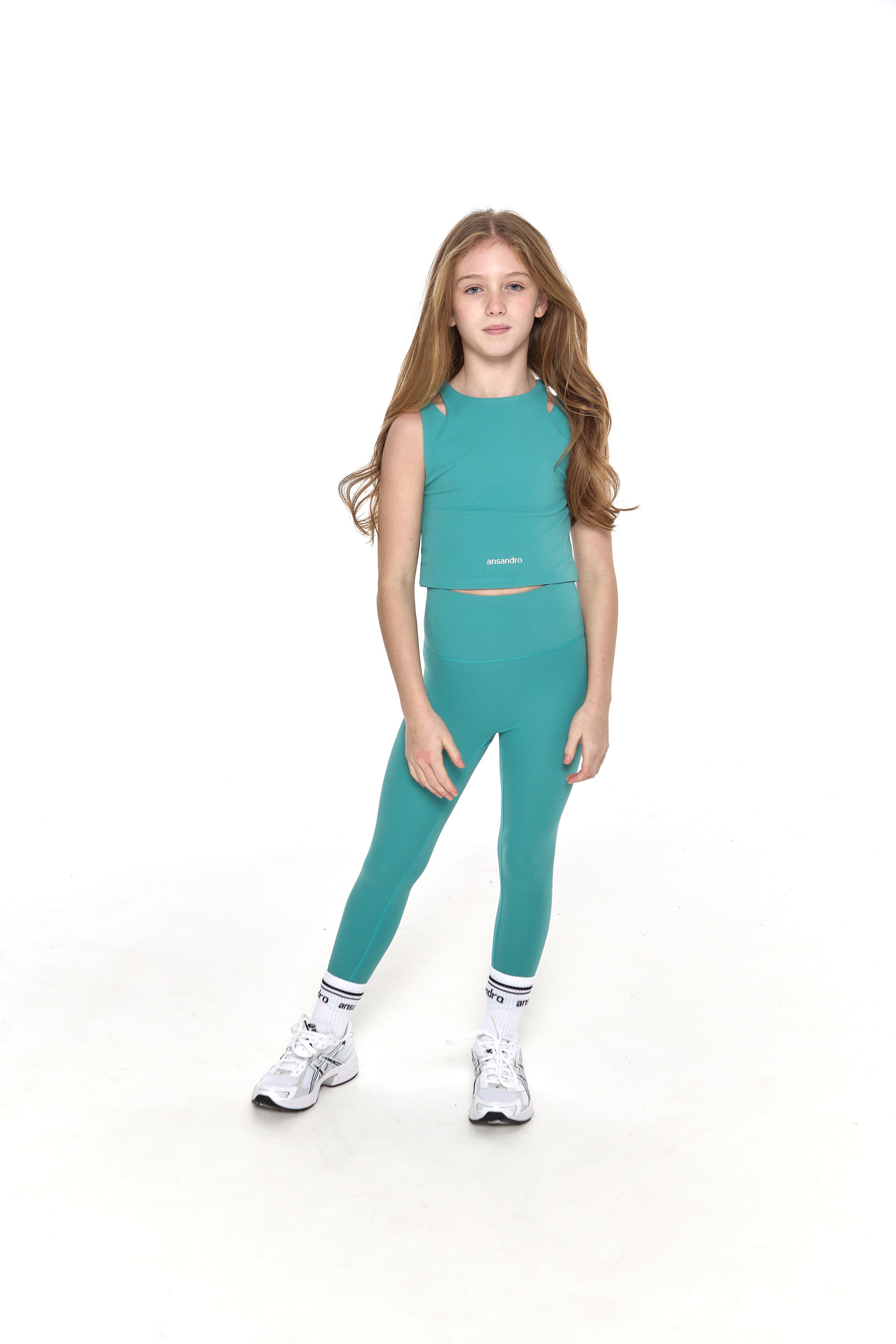 Cropped tank top for girls - breathable and durable design for active kids. Matching teal high-waisted leggings with branded socks