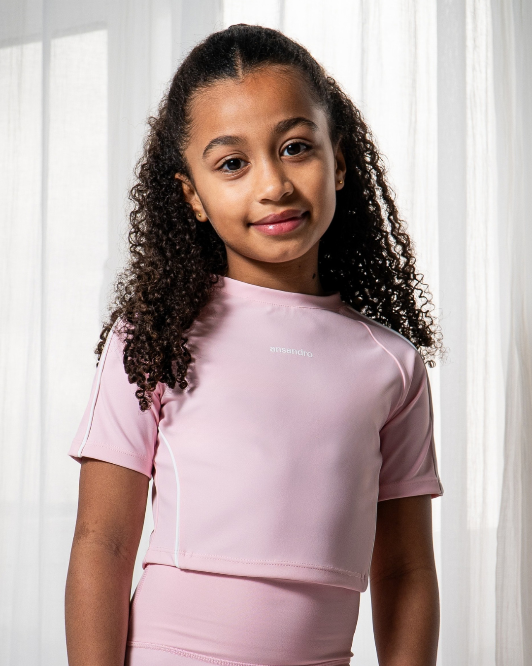 Young girl wearing a pink outfit with a blurred background