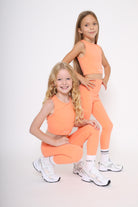 100% cotton branded socks with black text paired with girls bright high-waisted leggings and matching coral tank top