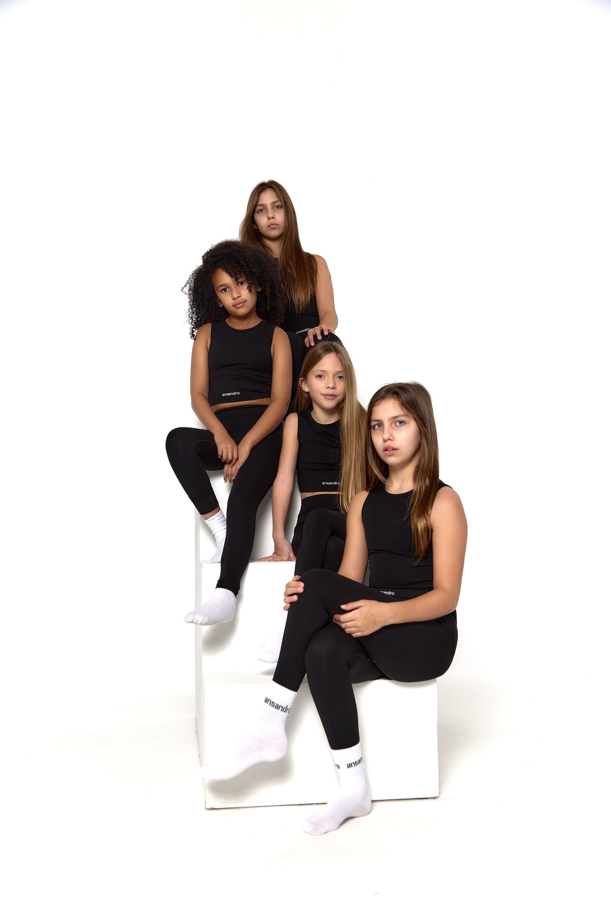 Ansandro girls' cropped tank in black - premium kids' activewear with matching black high-waisted leggings and branded socks front view
